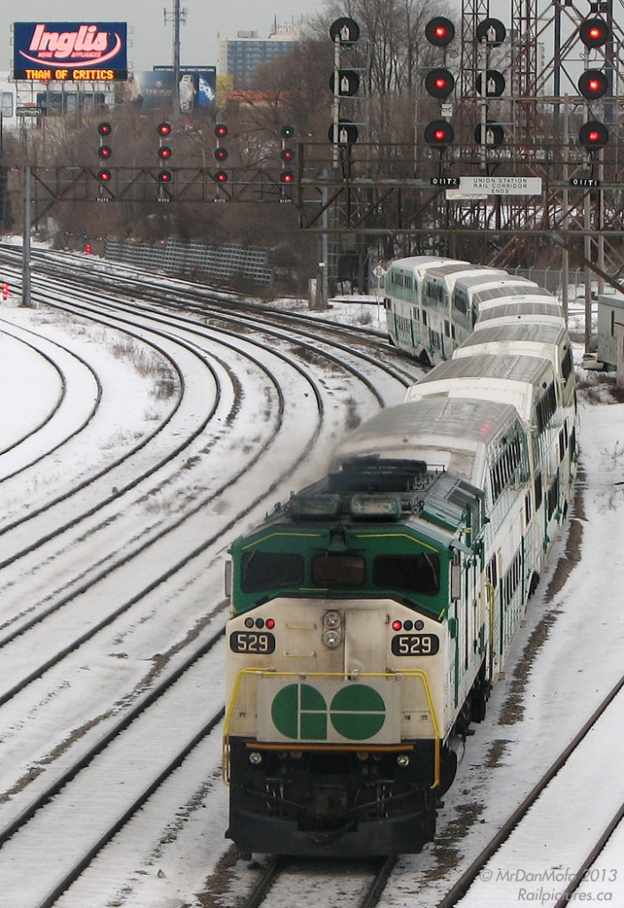 Early Bird gets the Worm.  A frigid early morning at Bathurst Street bridge finds GO 529, the only unit that kept its original numberboards, pushing an outbound train past Bathurst St. at 07:11 hrs. The neon glow of the famed Inglis sign lights up the background (later turned off at 8:00am), broadcasting inspirational messages on its LED display to traffic on the Gardiner Expressway. Today's message: "Children Have More - Need of Models - Than of Critics".  To shoot the morning rush, a few liberties were required. It usually went something line: rise by 4:00-4:30am (often on little sleep), a warm shower one was weary of leaving, brekkers, out the door by 5am to catch the 5:20am GO bus, to the 5:50am GO train, arriving at Union Station at 6:25am. Grab a muffin or Cinabon and walk the ~25 minutes (20 if you're really running) to Bathurst St. to shoot the morning rush from 7-9am. Then, go about whatever needed to be done in the city, albeit a little sleepy. If one was quick, they could shoot The Canadian leaving at ~9:05 at Bathurst, make it back to Union on foot with time to spare for the 9:30am train back to Bramalea, and be home before lunch (usually followed by a few hours' nap before the rest of the day).