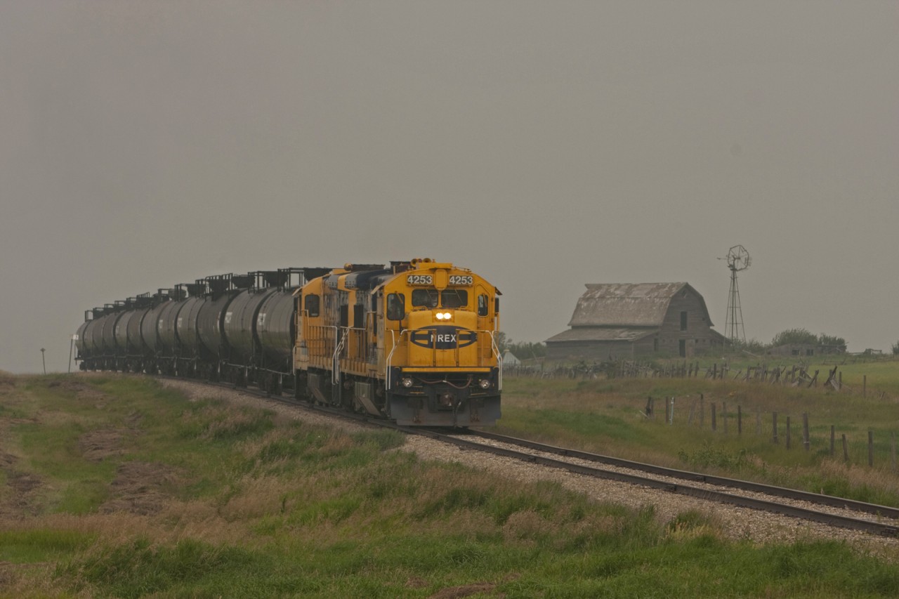 Great Sandhills Railway B23-7 #4253 and a sister are a few miles out of Leader headed for the gas plant at McNeil Alberta. The haze in the air is from forest fires buring in Alberta and British Columbia