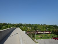 Built in 1914, the Heffernan St. pedestrian Bridge was constructed to avoid the then sprawling CPR Freight yard (and Freight shed tracks) in downtown Guelph, for pedestrians walking to their homes on the east side of the Speed River. In this scene, the Ontario Southland Railway is returning south after a long and hot muggy day of switching cars in North Guelph - with more work to do near lower yard in the south end before returning to Guelph Junction.