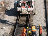Maintenance is a part of the railway that many don't see, yet it serves a very important purpose: to keep the system in top-shape and in working order for safe passage of passengers and freight. During the afternoon lull in train traffic, a group of maintenance workers tend to one of the many switches at the east side of Bathurst Street. Four workers divert their attention to the area around the switch's points and heaters, while one is ahead at the "frog" where the diverging rail crosses. Their hi-rail truck sits nearby; well-stocked with tools, welding equipment and other items needed to make a quick spot repair or do one of the many regular maintenance tasks in the corridor. <br><br> Also of interest, note the VIA stepbox on the ground by the side of the truck, probably a spare "borrowed" from somewhere around Union Station.
