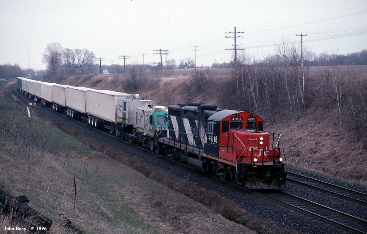 Trains 282 and 283 were the MOQ Ecorail intermodal trains in 1996. Similar to Roadrailer technology, but with the added feature of a control cab and distributed power modules instead of a conventional locomotive. That was the theory anyway. In practice, I never saw the power modules distributed within the train, instead they were always immediately behind the control cab. The train pictured is a typical late running 283, which had obviously had mechanical issues and was being rescued by a GP9. The trains' unreliability led within a short time to their replacement by Roadrailer trains 182 and 183, which themselves only lasted for about a year.