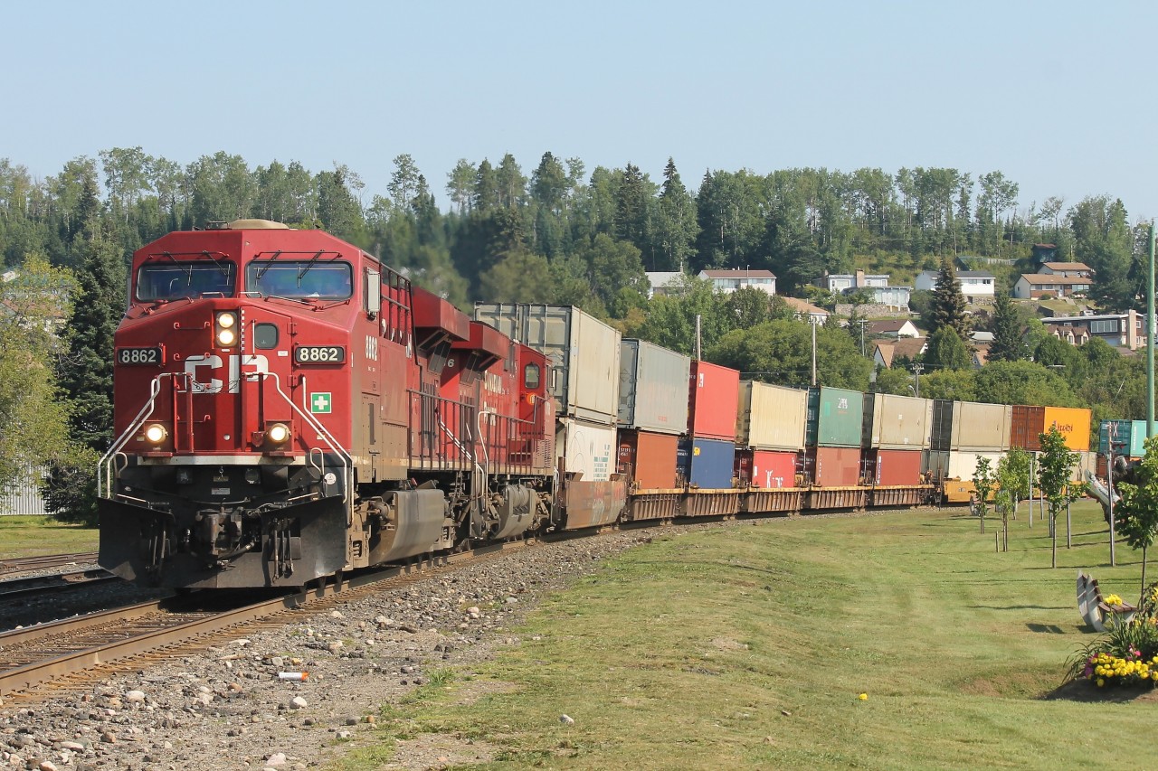 CP train 113 led by a pair of GEVO’s  -  8862 / 8736 - is passing through the heart of downtown Nipigon, Ont.  The grassy area in the forefront was, many years ago, part of the station grounds
