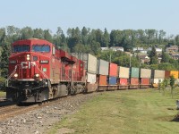 CP train 113 led by a pair of GEVO’s  -  8862 / 8736 - is passing through the heart of downtown Nipigon, Ont.  The grassy area in the forefront was, many years ago, part of the station grounds