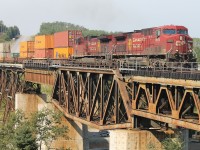 CP train 118 powered by a pair of GE’s - 9679 and 9829 - are almost across the Nipigon river on a combination of deck truss, plate girder and steel beam floor spans. On the north side of the railway and the highway structure [not visible] preliminary construction is underway for the first cable suspension highway bridge to be erected in Ontario.