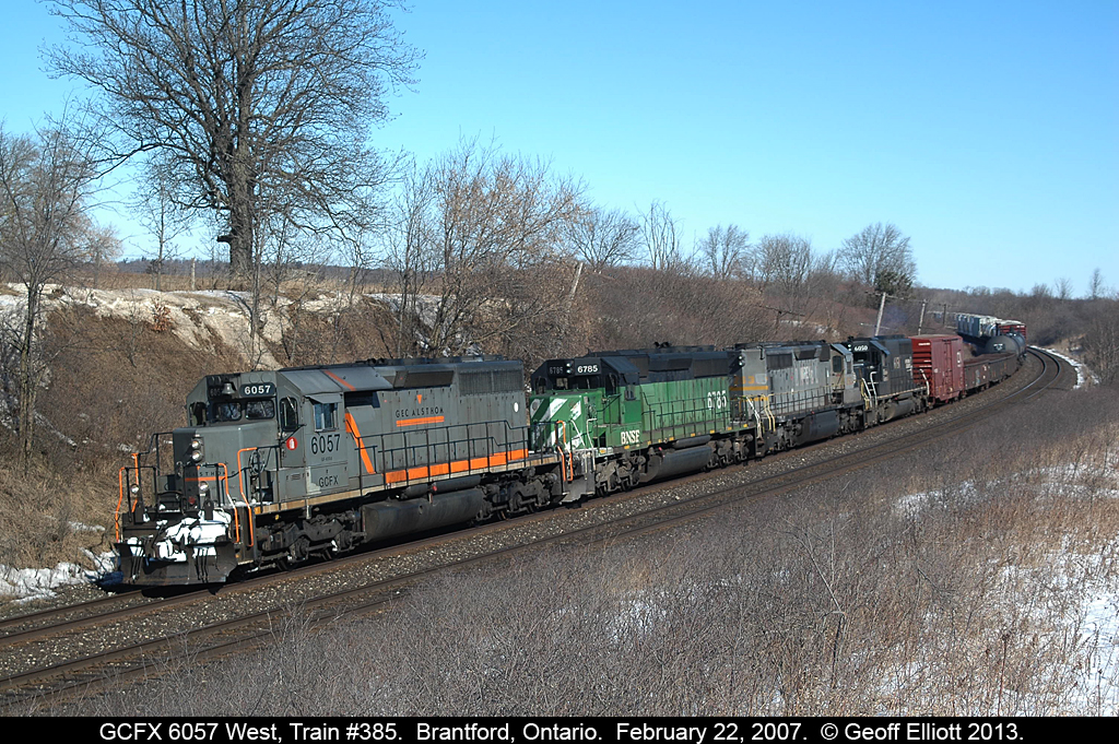 This is CN?? Yupp..... CN train #385 with GCFX 6057, BNSF 6785, NREX (ex-QNS&L) 263, and IC 6050 head westbound nearing CP Massey on CN's Dundas subdivision on a clear, but cold, February day.  I lucked out as I was driving from Toronto to Windsor and saw the train from the 403 climbing the hill in Dundas.  Had plenty of time to get ahead of the train, but sadly had to revert to digital as I had NO FILM in my camera when I got in position!!!  Still was lucky enough to get a shot off though.