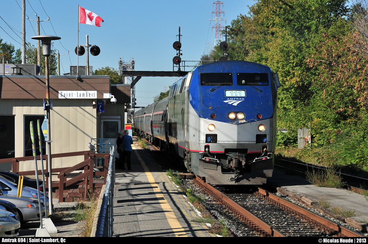 As the canadian flag waves, Amtrak #694 makes a little stop to Saint-Lambert station to pick up 2 passengers. In the background, you can see a part of the Victoria bridge.