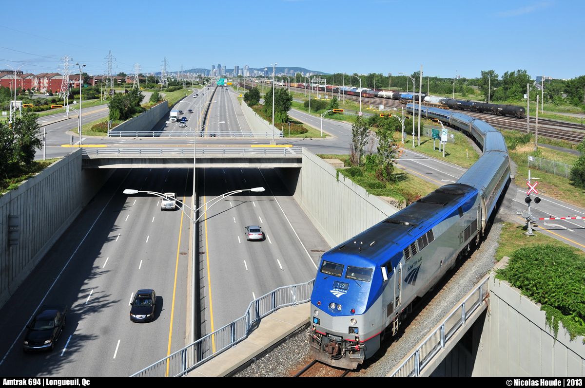 By a gorgeous morning, AMTRAK #694/68 (Montreal/New-York) cross the bridge over the highway 116 at Longueuil, QC. You can see the Montreal downtown in background, and the CN Southwark yard, in the right of the picture.