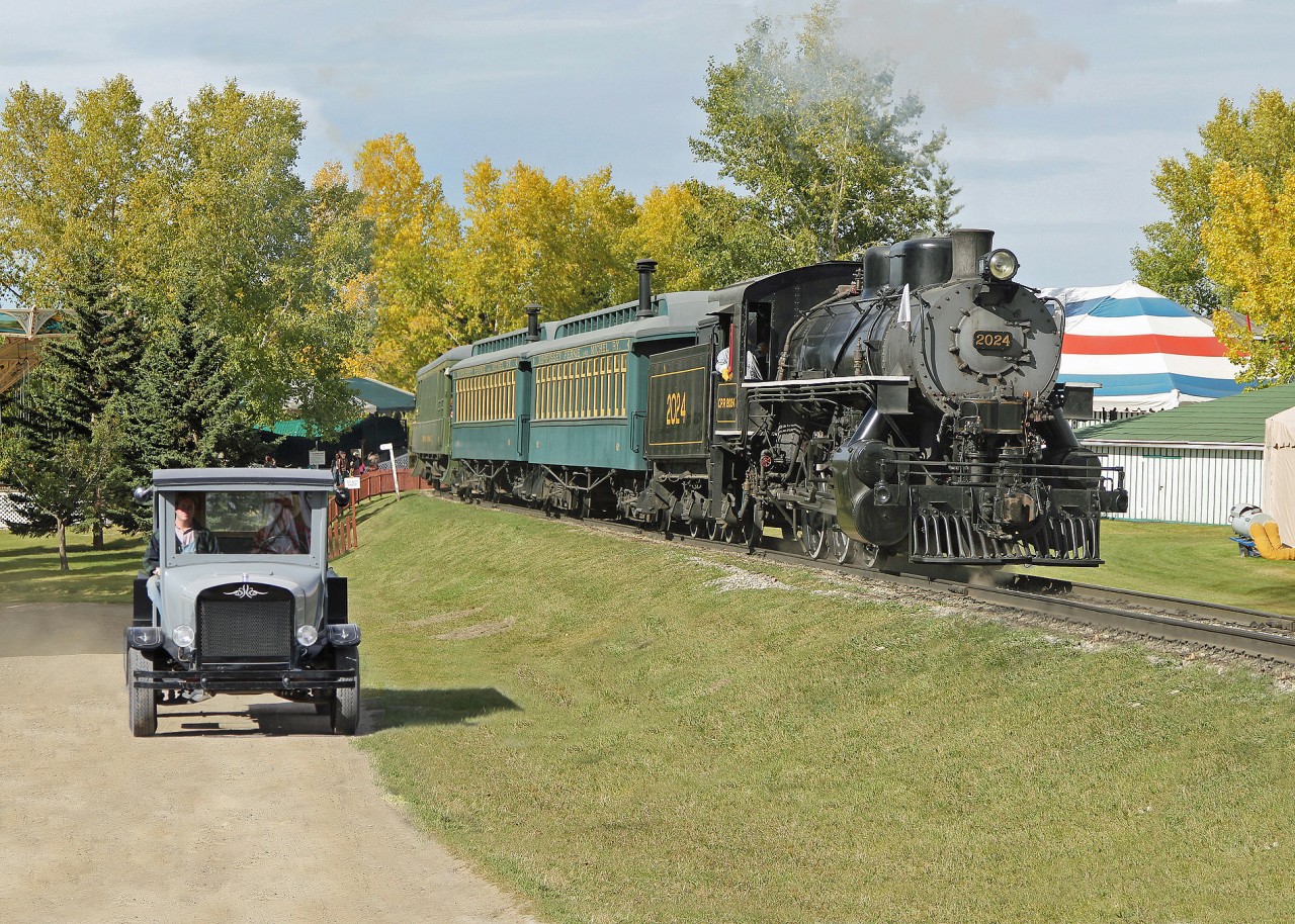 Another view of ex US Army Lima built 0-6-0 now at Heritage Park as CP 2024.  This time around being paced by one of Heritage Park's many vintage automobiles.  This is a pickup truck, the box is constructed from wood.  If anyone can identify the make and model from the radiator logo I would welcome the comment.