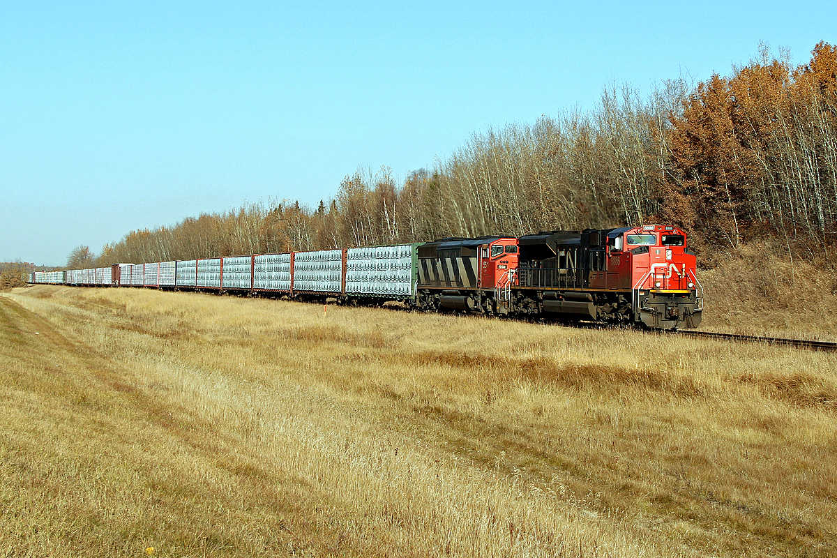 SD70M-2 CN 8886 and SD60F 5511 head an eastbound finished lumber train past North Cooking Lake.