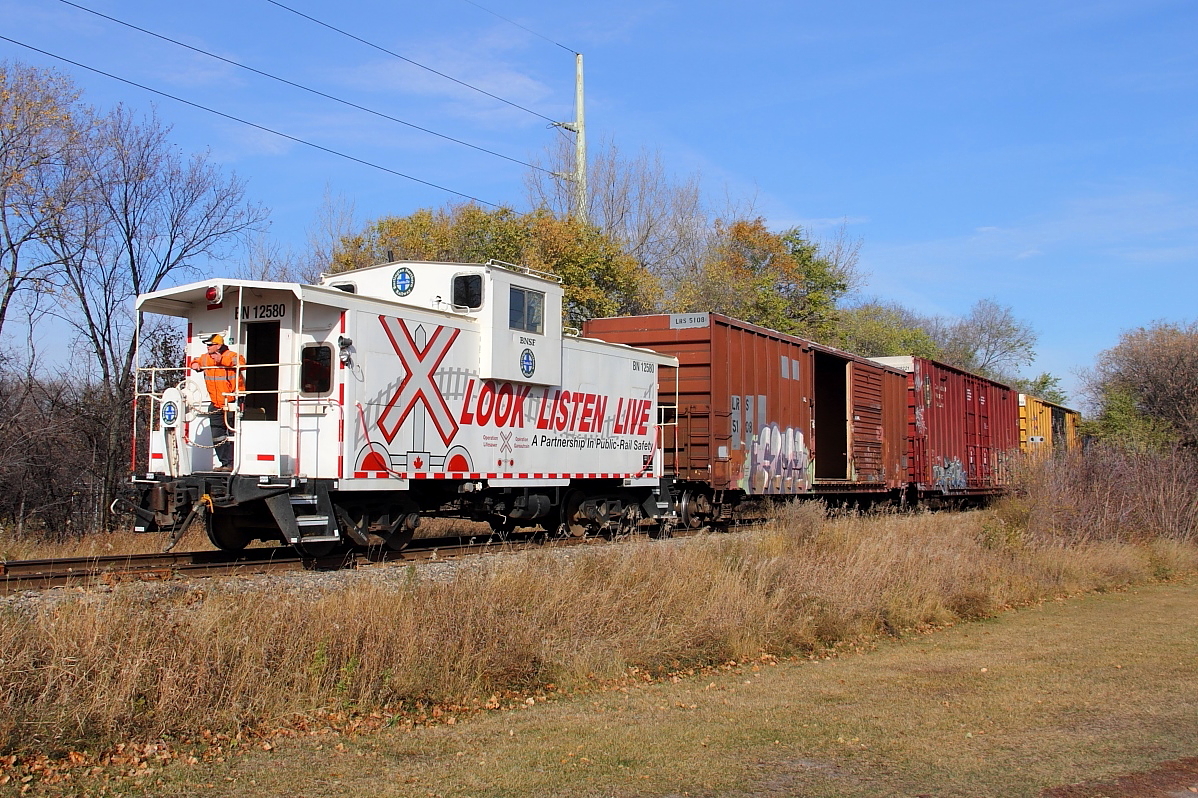BNSF's daily interchange run to CP's yard returns to the depot along CP's La Riviere Sub. The caboose is used for all back up moves.
