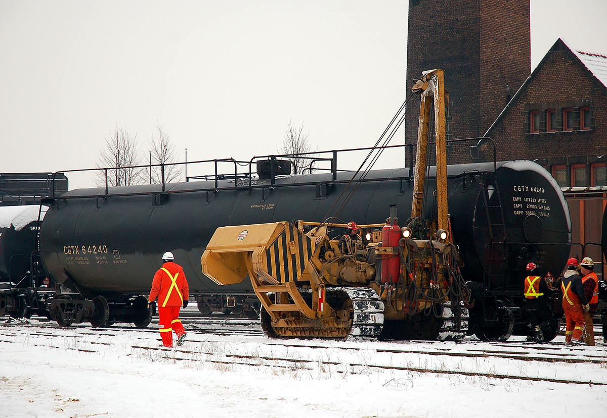 Crews from Hulcher's and CN work to rerail a few tankers that have been put on the ground by CN 398 the previous evening