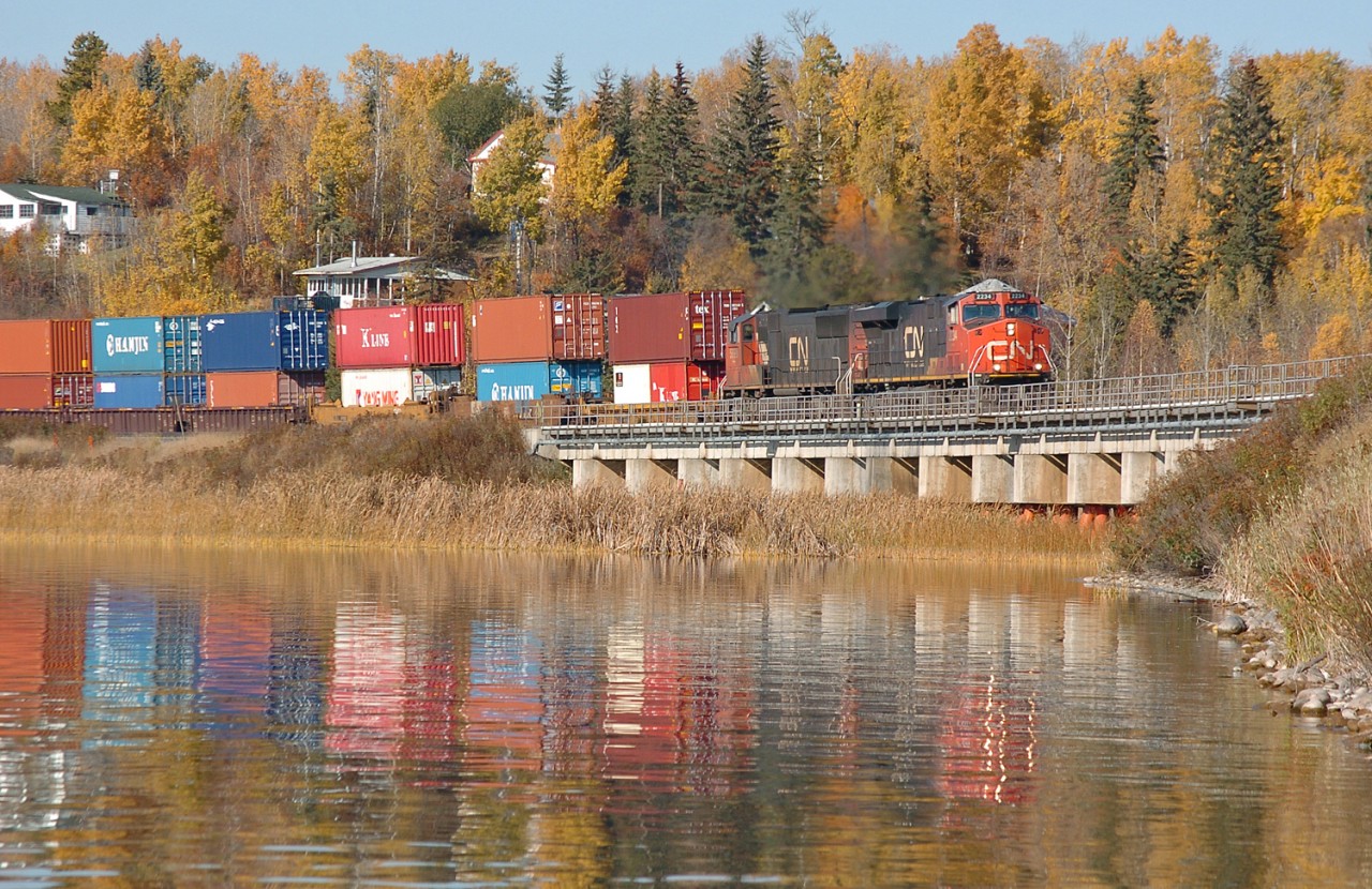 A long eastbound intermodal passes over a nice concrete bridge over Wabamun Lake on the Edson Sub. This particular bridge is often used by fishermen as a place to fish off of. Just before this train arrived there were about three fishermen out on the bridge.