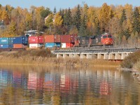 A long eastbound intermodal passes over a nice concrete bridge over Wabamun Lake on the Edson Sub. This particular bridge is often used by fishermen as a place to fish off of. Just before this train arrived there were about three fishermen out on the bridge. 