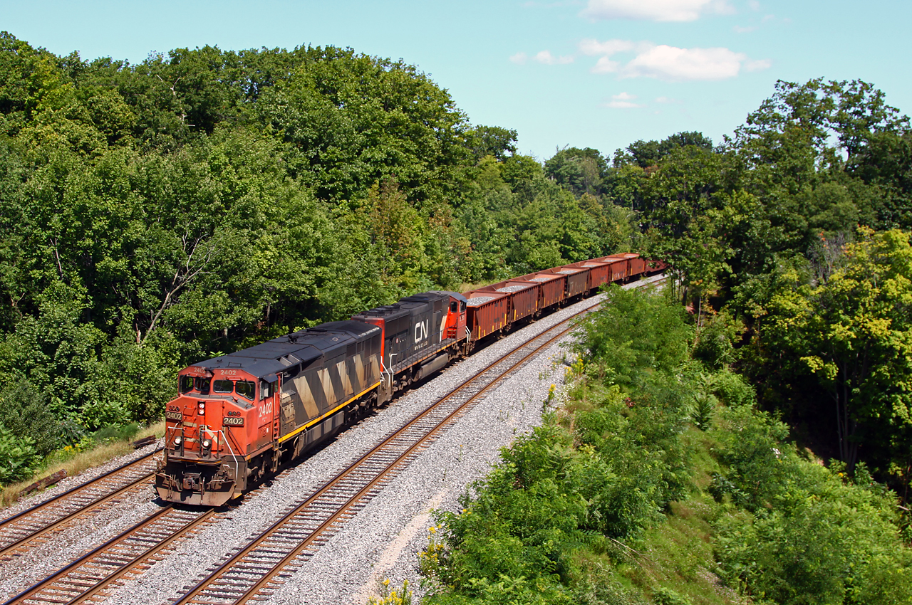 Hard to believe this is almost four years ago, we find CN's management "training train" or "scab train" westbound at Bayview. At the time, the train was running with about 80 cars IIRC, some loaded ballast cars to give the train a more accurate weight compared to regular freights and the majority of the train empty centrebeams. Most trains ran from Mac yard to Paris and return, but some later trains only ran to Bayview and back. I believe the trains ran for about two years (might have been three?), with the consist changing from time to time (later empty coil cars were used); often, there were two turns to Paris in one day, one in the morning and one in the afternoon. The trains proved their worth when CN conductors went on strike, and management kept the wheels rolling on most freights.