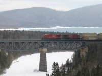 It is midafternoon on one of those spring days where you wish the sun would come out yet the cloud cover persists and the raw, damp temperature causes the shivers. Eastbound intermodal 118, with cp8836 and cp9511 up front, clatter across the Little Pic River bridge. This is the view that one sees looking lakeside when motoring across the highway bridge, especially if you are lucky enough to catch a train here.