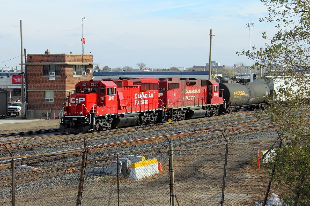 One of CP's new GP20C-ECOs and a GP38-2 lead a local out of the yard past the old tower at Rugby Junction.