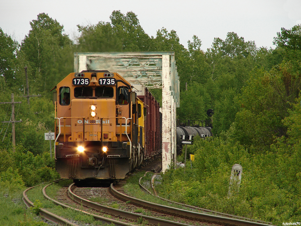 ONT 214 - ONT 1735 South hammers over the impressive trestle that spans the Latchford dam, an interchange for the Montreal river, with 62 cars in tow for connection with CN at North Bay.
