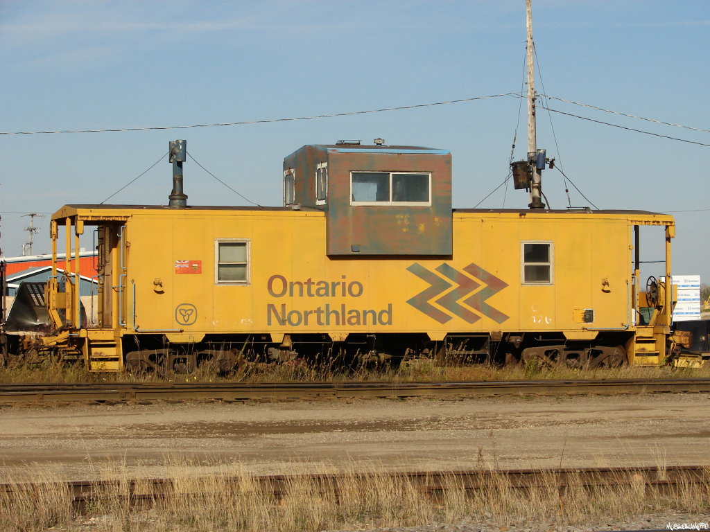 ONT 126 in excellent shape, esthetically, sits on the RIP track with an old green 40' boxcar soaking up some fall sunshine in Hearst.