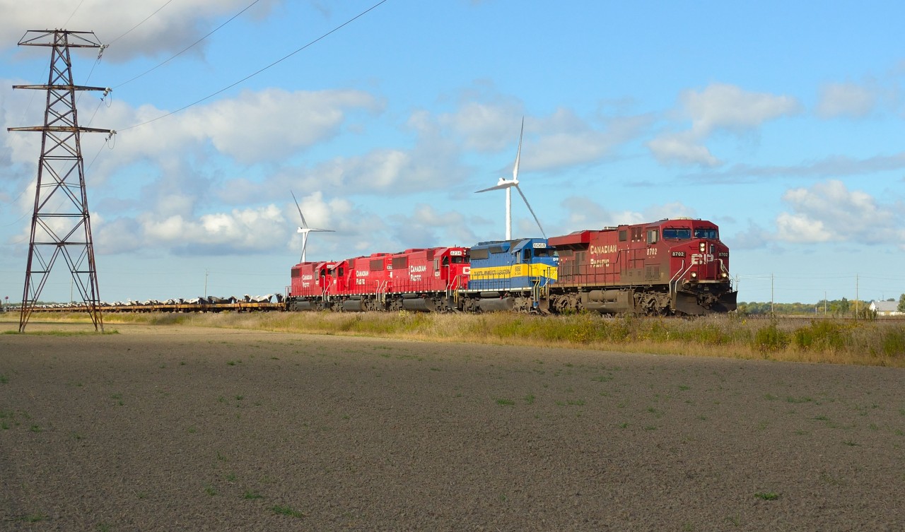 CP 240 led by a GE, DME and a trio of rebuilt ex SOO's passes eastbound thru Haycroft. The headend had a long string of empty windmill flats.