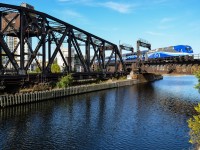 AMT 1365 is pushing a deadhead movement over the Lachine Canal, later the train will depart for the south shore on the Mont St-Hilaire line. The bridge to the left used to be CN's entry point to the Port of Montreal. It has been out of use about 20 years and is locked in place; CN accesses the Port of Montreal through a newer bridge a bit to the east. For more train photos, check out http://www.flickr.com/photos/mtlwestrailfan/ 