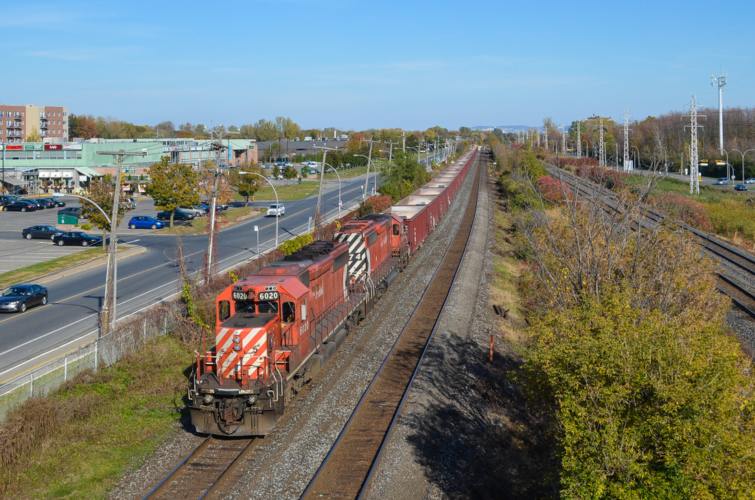 A partially loaded ballast train heads west through Pointe-Claire. Power is CP 6020 & CP 5874, both with multimarks. At the rear is caboose CP 434957. CP has been doing a lot of trackwork this past weekend on the Vaudreuil Sub, causing cancellation of commuter trains on this line. For more train photos, check out http://www.flickr.com/photos/mtlwestrailfan/