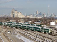 <b><i>Inner Suburbs / The GO Stay While They Wait to Play</i></b>
<br><br>
Due to the loss of train storage capacity downtown because of the then-ongoing expansion of GO Bathurst North Yard, GO instead stored some of its trains at VIA's Toronto Maintenance Centre, on the VIA side of the "inner suburb" of Mimico. Three GO green consists sit side-by-side at the TMC, with the downtown Toronto skyline in the background where they will soon be headed to load up evening passengers for further-away GTA suburbs.
<br><br>
For the record, the "L10" 10-car consists lined up from left to right:<br><i>
GO 237-607<br>
GO 204-612<br>
GO 246-610</i>