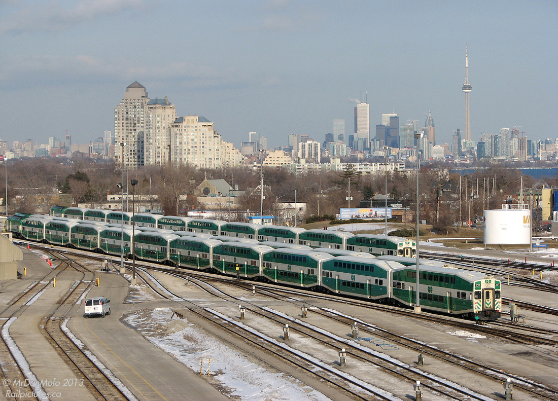 Inner Suburbs / The GO Stay While They Wait to Play

Due to the loss of train storage capacity downtown because of the then-ongoing expansion of GO Bathurst North Yard, GO instead stored some of its trains at VIA's Toronto Maintenance Centre, on the VIA side of the "inner suburb" of Mimico. Three GO green consists sit side-by-side at the TMC, with the downtown Toronto skyline in the background where they will soon be headed to load up evening passengers for further-away GTA suburbs.

For the record, the "L10" 10-car consists lined up from left to right:
GO 237-607
GO 204-612
GO 246-610
