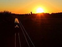 A eastbound VIA train fly's through the signals and under the Newtonville road bridge as the sun sets 