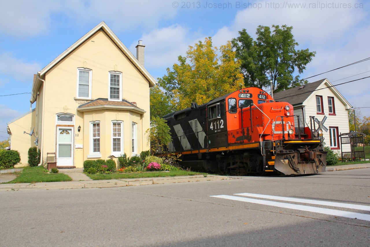 CN 4112 rumbles past the houses on Port Street in down town Brantford Ontario on a sunny Wednesday morning.