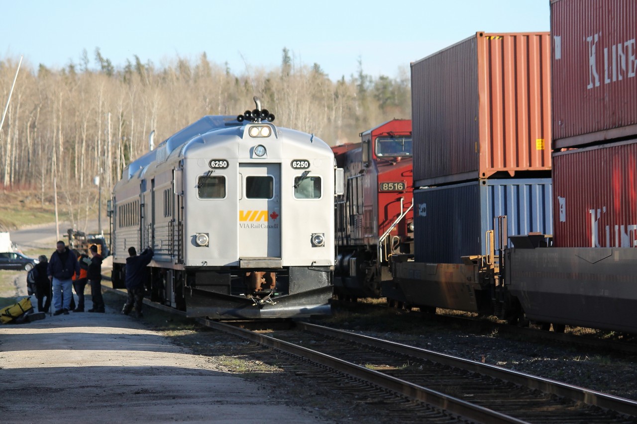 VIA 185 has arrived at White River, Ontario and is holding the mainline to detrain the passengers in front of the old station building. On the adjacent passing track an eastbound intermodal creeps by. Once the passengers and the eastbound are all clear, the VIA crew will park the rail diesel cars in the yard until the return trip tomorrow morning.