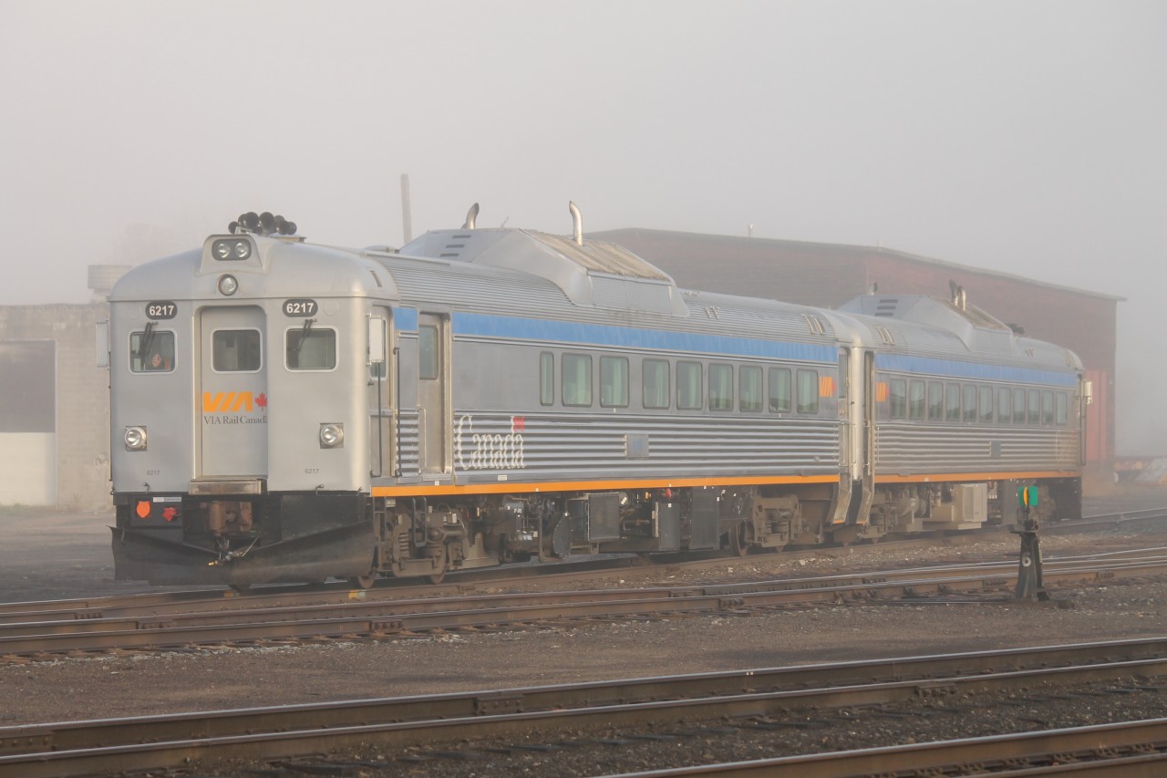 Early morning in White River, Ontario. The fog is slowly melting as the rays of the rising sun shine through revealing the pair of VIA diesel rails cars that overnighted in the yard. The crew will be boarding soon to prepare for the return trip to Sudbury.