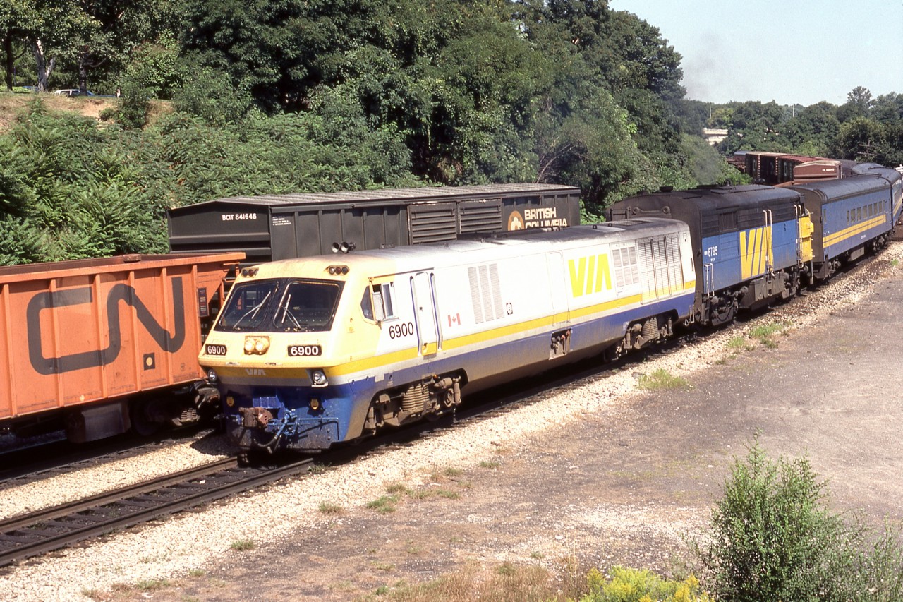 Busy Junction. Three year old LRC-2 6900 leads older cousin FPA-4 6785 on VIA 73 upbound through Bayview past a stopped lower priority CN freight train. The LRC, MLW’s final passenger locomotive effort, though temperamental and often unreliable, would prove to be the last Alco Schenectady descendant to see main line service. Delivery of newer power would end the careers of both of the 251 engined units;  GMD supplied F40PH-2’s in 1987 would idle 1959 built 6785, whereas P42DC’s from GE in 2001 would cause VIA to set aside class unit 6900. Sadly, neither unit would be preserved.