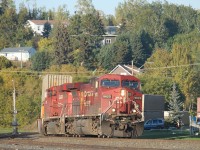 Train 113 led by CP 9623 and CP 8878 rounds the curve in downtown Nipigon at the main street crossing.