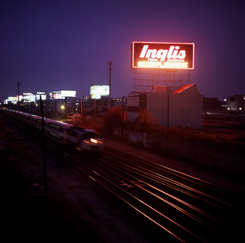 An eastbound GO pounds the plant at Fort York under the pink glow of the (original) Inglis sign.  This scene has changed quite a bit.