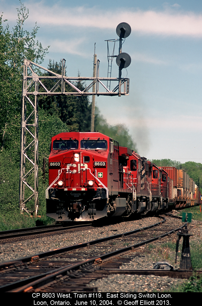 CP 8603 has train #119 in hand as it passes under the cantilever signal that governs eastbound movements on the trans-continental main at the East Siding Switch Loon, in Loon, Ontario back in 2004.