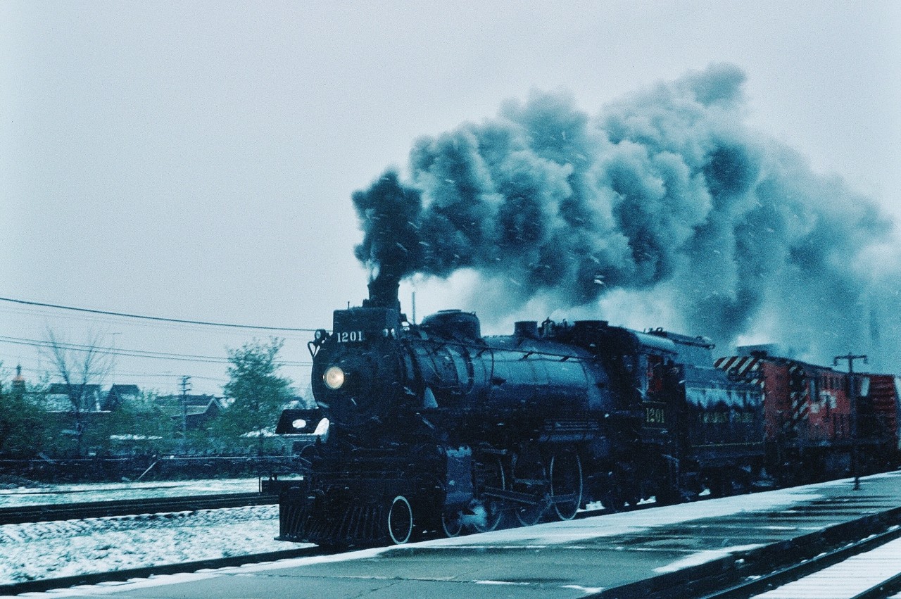 Modern Diesel Power meets Modern Steam Power – or – an ' only on CP ' lashup !


Perhaps the first time 8921 assisted by Steam: Ex CPR G5a #1201 is the Transfer's  helper on April 26, 1976  with the former on the break in run after an extensive rebuild at the CP Rail John Street roundhouse. 


and the RSD17 is the unique locomotive of the two ! 


For decades the MLW RSD17  -  8921  -  was  the regular ( Toronto ) power for ' The Transfer ' 


Not so rare: the CPR class G5 is one of 103 owned (1200 to 1301)...and truly modern with CPR built #1201 being a mere youngster at 32 years on this 1976 day...with Frank Bunker at the throttle.


On an absolutely  miserable - weather wise – April 26, 1976 day,  a  Pre-SLR  Kodachrome at the CP Rail West Toronto station.


What's interesting:
For years the CP Rail John Street roundhouse quietly accommodated privately owned motive power and rolling stock. (John Clarke was one of the CP Foreman at the roundhouse ). Stored motive power included Royal Hudson 2839 (at one time owned by the Ontario Science Centre, then onto active Southern Railway service, now static in California),  ex CNR Pacific #5107 (at one time owned by the Ontario Science Centre, now in Kapuskasing), ex CPR Mikado #5361 (at one time owned by the Ontario Science Centre, now in Depew, N.Y.), ex CPR D10 #1057 and #136  and CPR S-2 #7020 plus storage of various pieces of rolling stock –  including the Upper Canada Railway Society car 13 (former CPR Cape Race).


Southern Ontario Mainline Steam at various times throughout the Seventies : 136, 1057, 1201, LNER 4472 (The Flying Scotsman), 6218, 6060, and BCR 2860 also made an appearance spring 1978. (and Sixties Mainline Steam included 137 and 2857 and 6167 and 6218). Other mainline steam you are aware of ?


Postscript: on a May 1976 Sunday morning 1201 powered the Ontario Rail passenger cars on an equipment move over the Belleville Subdivision to Smith Falls and onto the National Museum in Ottawa. (I know there are pics out there – someone ? !)


Post postscript: yes the 1201 – 8921 lashup descended the Don Branch grade!


What's interesting:


CPR built only two G5's: 1200 and 1201; all other G5's to 1301 built by MLW.


MLW built H1e Royal Hudson 2860 MU'd with not one but two GMD F7B units - the 1978 Discover British Columbia Tour - and indeed 2860 was MU'd, a GMD control stand was installed in 2860's cab!


     at Cherry Street