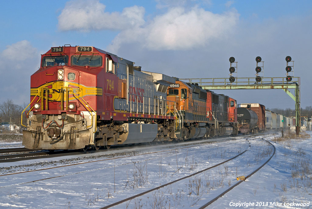 Having passed through town about five hours earlier on CN train 148, BNSF 794 now leads CN train 399, spelling for the ailing CN 5667 now trailing. A complicated series of moves, including wying the 794 and 399's power at Bayview Jct., were necessary to get it facing the right direction . With the aid of BNSF 6946, this train is now essentially all BNSF powered (the second one of the day). Cloud and snow squalls blew through all day long, but the two most interesting trains of the day were both greeted by sunshine here. 1636hrs.