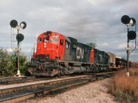 With the onslaught of GP40-2L(W)locomotives, of which more than 275 were on the scene by 1976, it was becoming increasingly difficult to catch CN trains powered by MLW C-630M diesels.  Pictured here are CN 2007, 2009 westbound thru the signals at Mile 2, Dundas, just before going over the York Rd bridge. Note open auto cars, and TOFC; both of which are never seen today. This is still a reasonable photo location, mid-afternoon and on.
