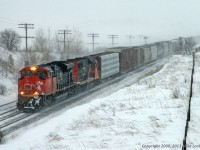 In the midst of a heavy snowstorm, CN 8006 and 5373 battle eastward with 320's train. Had it not been for the storm, the summit of the climb from Newcastle to Newtonville would almost be in sight, though calling it a summit is probably an overstatement as this is not exactly a legendary grade. It is, however, a slog for many an eastbound with the tendency of CN to assign just enough power to get over the road, not allow the engineer to exceed run 6 in order to conserve fuel, and even isolate a unit if it is deemed the train has an abundance of power. As I recall, this hogger was every bit of power that he could out of this pair; the whine of the turbo's being rather pronounced even with the snow deadening the sound. 1518hrs.