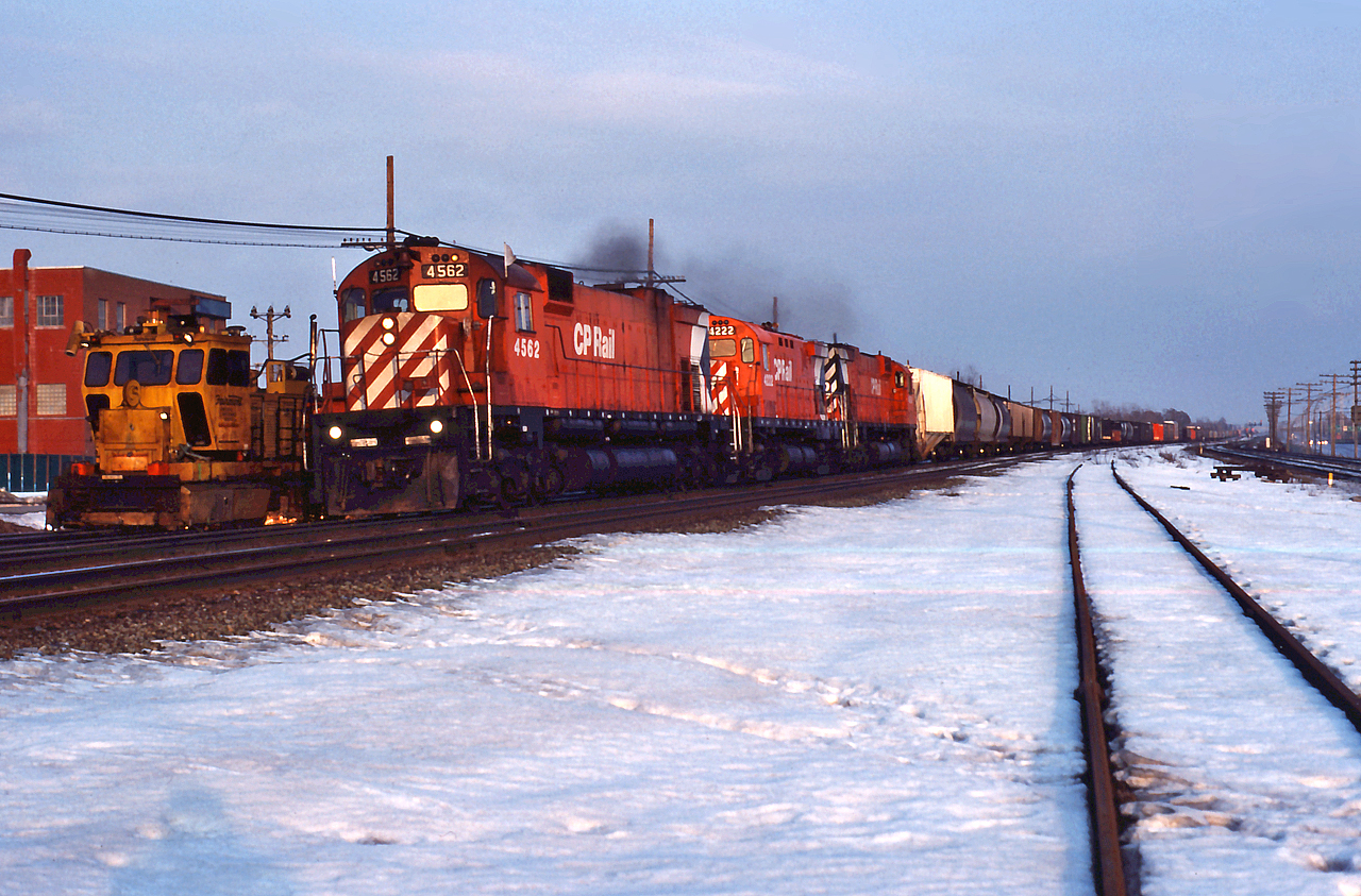 CP 507 highballs through Dorval past a Railgrinder, with a trio of MLWs.