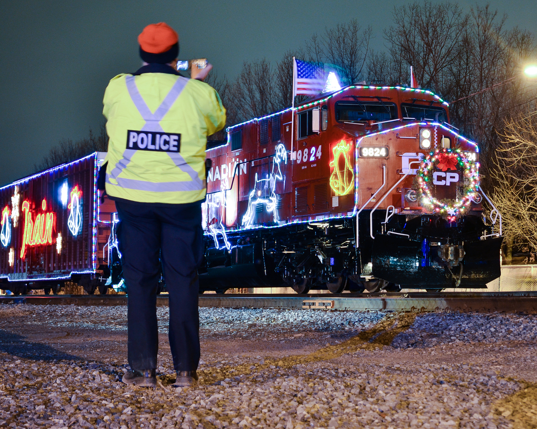 Everyone wants to photograph the CP holiday train! Even a CP police officer wants a shot of it.....This is the U.S. CP Holiday train, stopped at Delson, Quebec. For more train photos, check out http://www.flickr.com/photos/mtlwestrailfan/