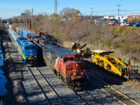 <b>A pair of eastbounds.</b> VIA 52 (inbound from Toronto) with VIA 904 in the lead is about to blow by CN 394 (bound for Richmond, Qc) which has just left nearby Taschereau Yard. Leading the CN train are CN 2449 (with modified radiators) and CN 8945. To the right is some MoW equipment; CN has been doing a lot of trackwork on the Montreal Sub recently. For more train photos, check out http://www.flickr.com/photos/mtlwestrailfan/