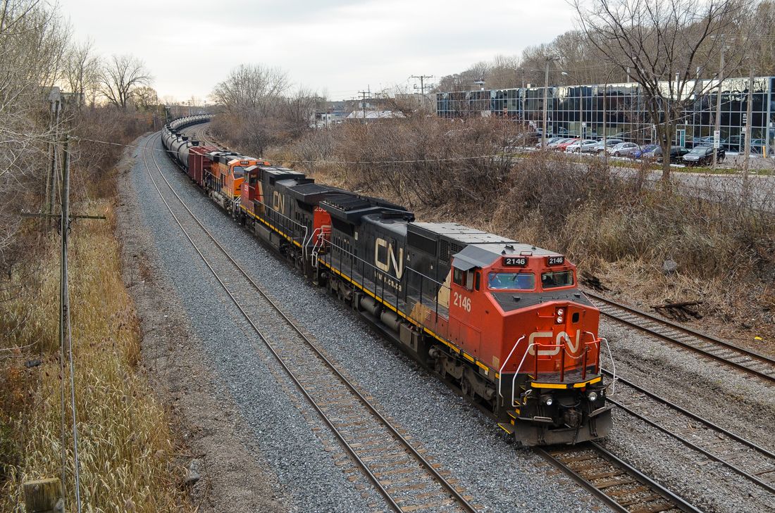 CN U710 (loaded oil train) is heading east through Ville St-Pierre on the island of Montreal. Lead engine is an ex-BNSF Unit (CN 2146), second unit is CN 2558 and third unit is BNSF 6584 (a fairly new GE ES44C4). BNSF units in Montreal are almost unheard of but will probably become more common with the upswing in CN oil trains. For more train photos, check out http://www.flickr.com/photos/mtlwestrailfan/