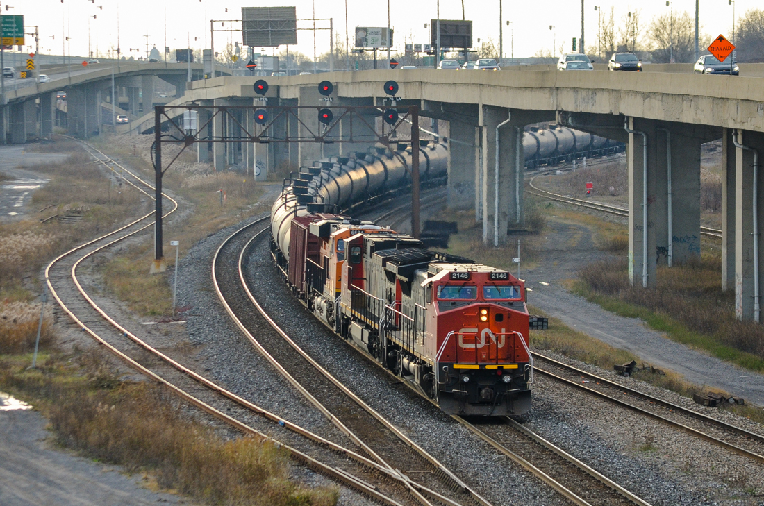 CN U710 (loaded oil train) departs eastwards after changing crews at Turcot West. Lead engine is an ex-BNSF Unit (CN 2146), second unit is CN 2558 and third unit is BNSF 6584 (a fairly new GE ES44C4). BNSF units in Montreal are almost unheard of but will probably become more common with the upswing in CN oil trains. To the left is a spur which leads to Canadian Allied Diesel in Lachine, up until the early 1960s that was CN's main line to points west of Montreal. For more train photos, check out http://www.flickr.com/photos/mtlwestrailfan/