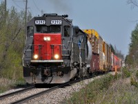 Returning from MacMillan Yard, 431 passes through the rolling countryside between Acton and Rockwood. On this warm spring day the loads included a gondola of utility poles and a string of Potash Corp hoppers.