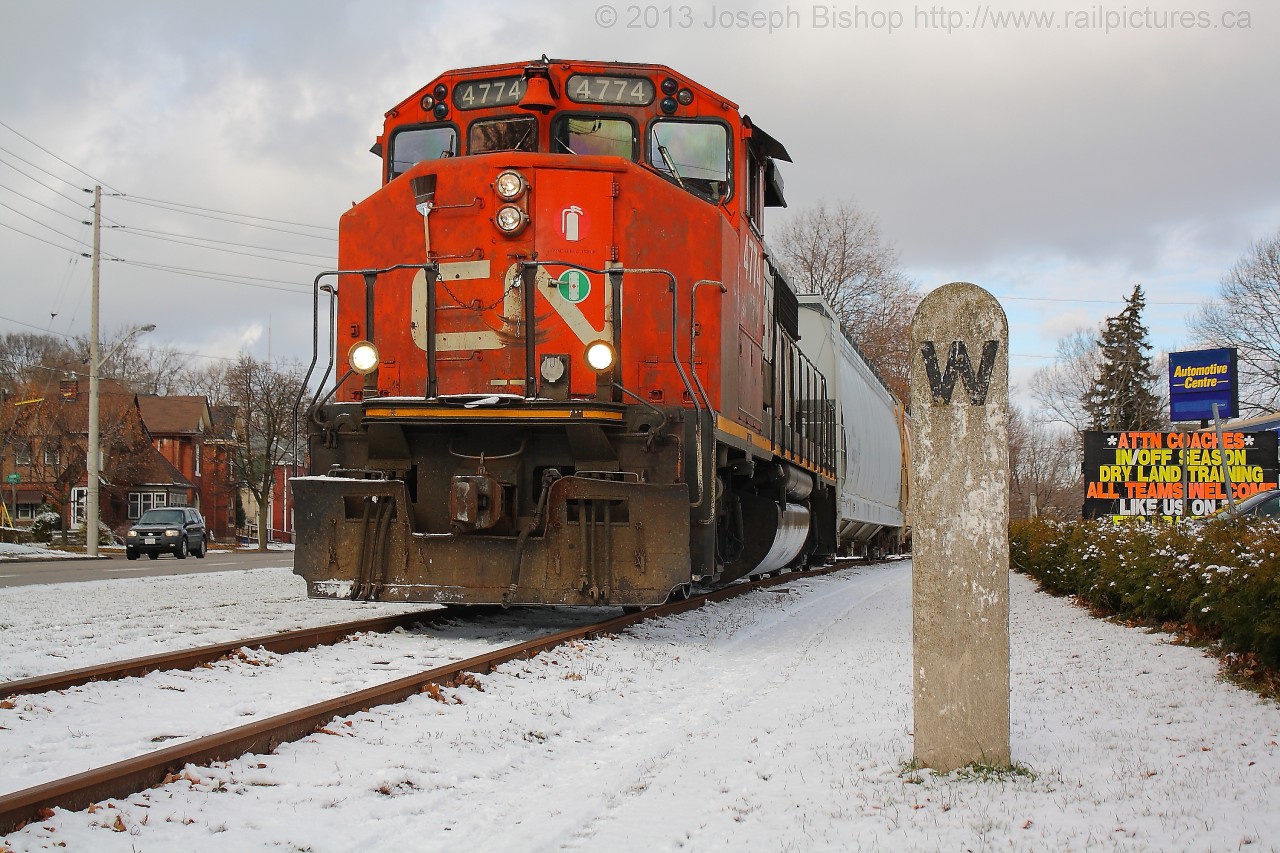 CN 4774 trundles down the Burford Spur past one of two unique concrete whistle posts on the line.  The night before saw the first snowfall of the year making for a nice shot.  The whistle post dates back to the TH&B era on the line.  No doubt it has seen many an interesting train pass by it.