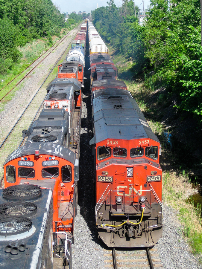 On the right CN 401 with CN 2453, BCOL 4642 & BCOL 4623 head west towards nearby Taschereau Yard, passing a stopped CN 527 with CN 9584, CN 7031, CN 4724 & CN 9524 as power. For more train photos, check out http://www.flickr.com/photos/mtlwestrailfan/