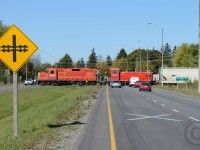 <br>Ontario Southland Railway backing their train across Highway 6/7 in Guelph, also known as the Hanlon Expressway. In a few years this highway should be extended directly north to connect to Highway 85 in Kitchener, and it is expected this crossing will be closed and the at-grade crossing behind the photographer will be turned into an overpass.<br><br>
Trains crossing 'divided highways' are rare - and in 1969 the Railway built two spur lines (South and North Industrial) months before the Ministry of Transportation of Ontario decided to build a highway/bypass of Highway 6 through Guelph. New at-grade crossings like this would never be permitted today without an underpass/overpass. Do any railpictures.ca viewers have photos of Trains crossing divided highways at grade?