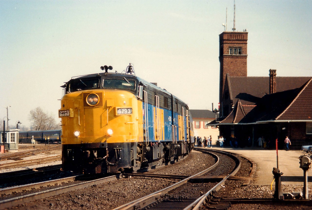 VIA 6793, paired with 6782, is looking good in fresh paint as she rolls to a station stop at Brantford on March 8, 1987. The late afternoon #75 was back then quite the long train.