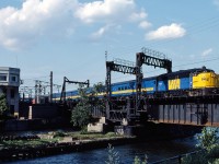 VIA 24 led by FPA-4 6774 crosses the Lachine Canal at Wellington on a beautiful summer day.